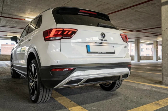 Caméra de recul intégrée au pare-chocs arrière d'un VW T-Roc blanc dans un parking souterrain urbain